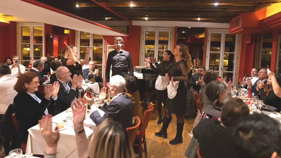 Chanteurs debout dans un restaurant applaudis par les clients assis à leurs tables