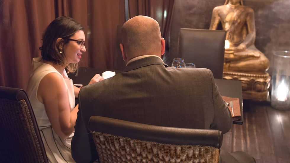 Un bărbat și o femeie stau în jurul unei mese într-un salon privat al unui restaurant romantic din Paris