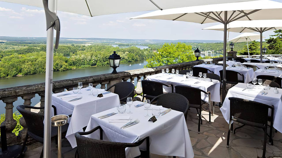 Stoły w restauracji na tarasie z panoramicznym widokiem na dolinę w okolicach Paryża