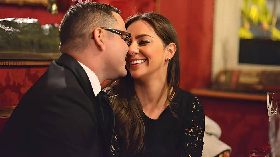 Un homme et une femme s'embrassent sur la banquette d'un restaurant romantique de Paris