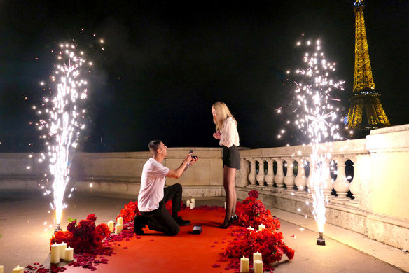 Demande en mariage romantique sur tapis rouge avec bougies, étincelles et tour Eiffel de nuit