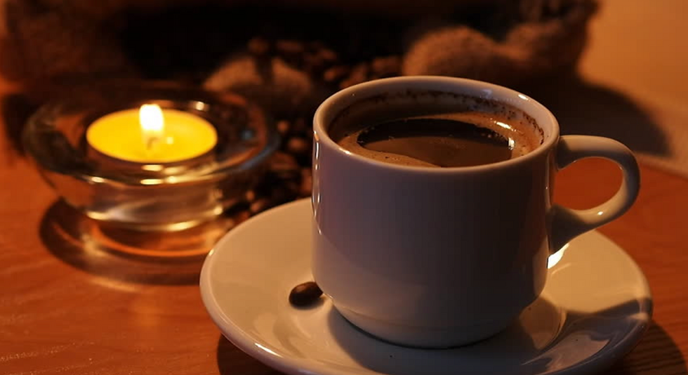 10637335-cup-of-coffee-and-candle-in-the-form-of-heart-on-a-black-background