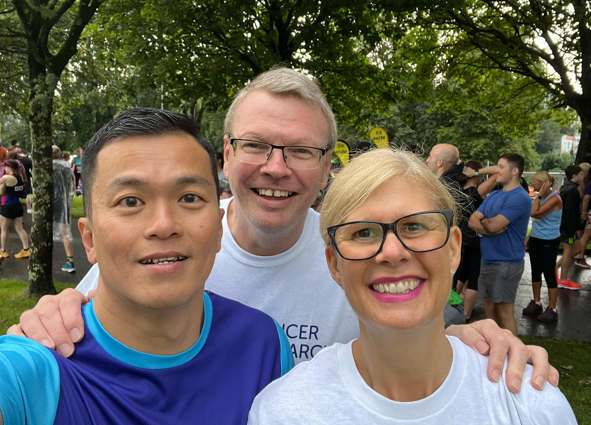 Three people smiling outside