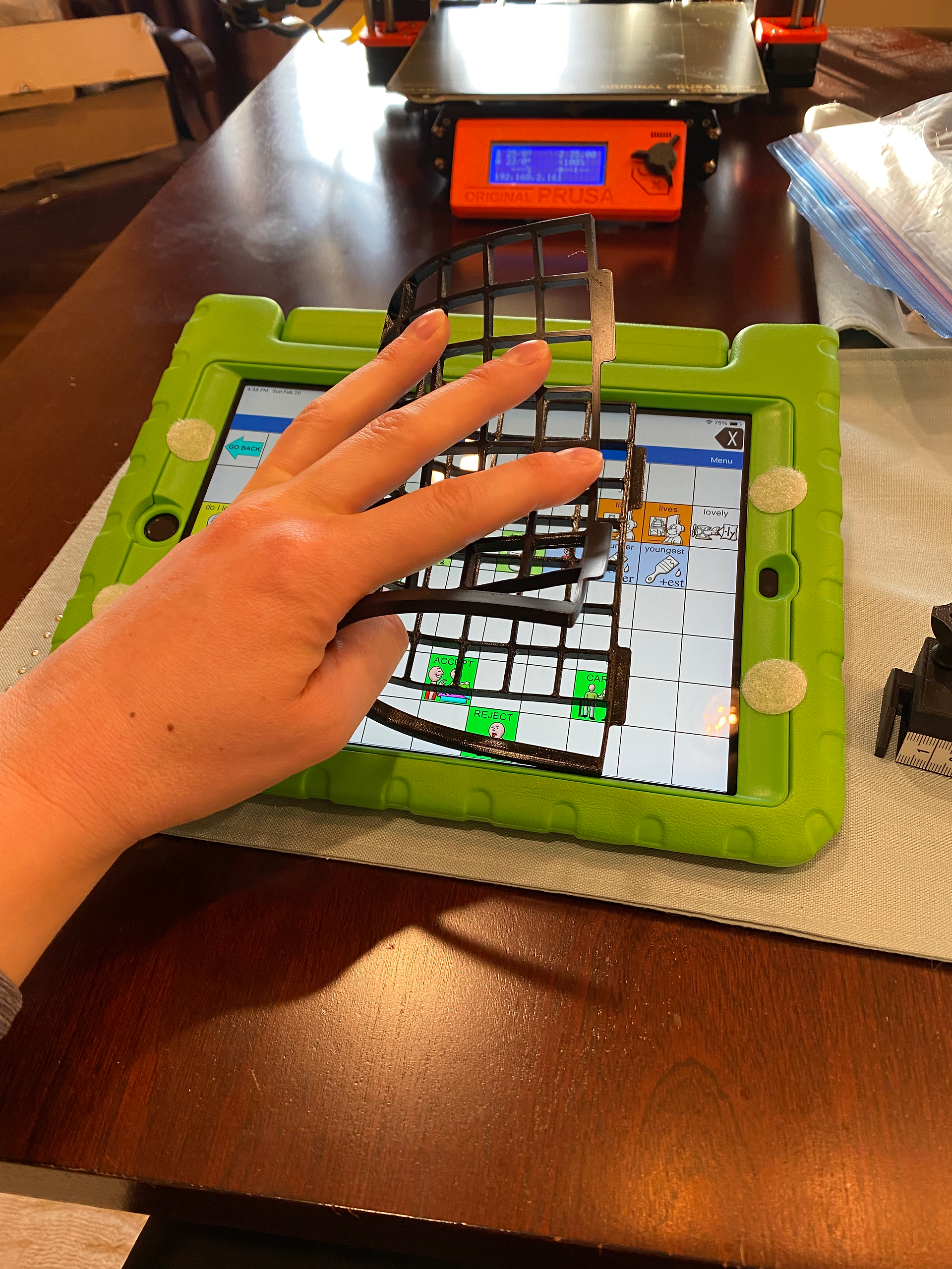 A keyguard made of PETG that is bent in half to demonstrate the flexibility of the filament.  The keyguard is on top of an iPad
