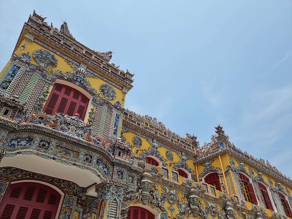 Image of a historic building within the Hue Imperial City. The building is very ornate in the Chinese/Vietnamese style and is coloured yellow.
