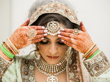 Bride with intricate mehndi framing her maang tikka and bridal jewelry