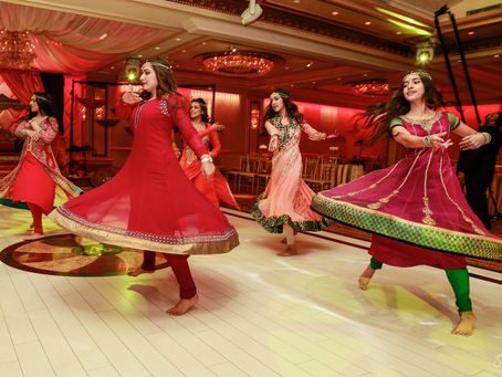 Guests in colorful anarkalis dancing at a mehndi night