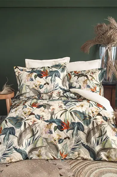 one of our bed sets called spasso made of 60% tencel and 40% pamuk. the bed set has big green leaves with white floers and a pop of red.