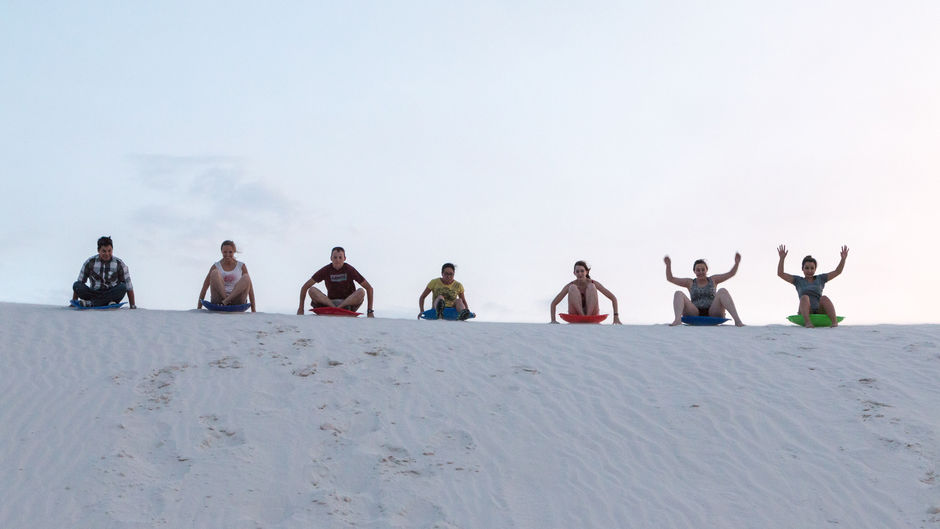 people on sleds at White Sands National Park in New Mexico
