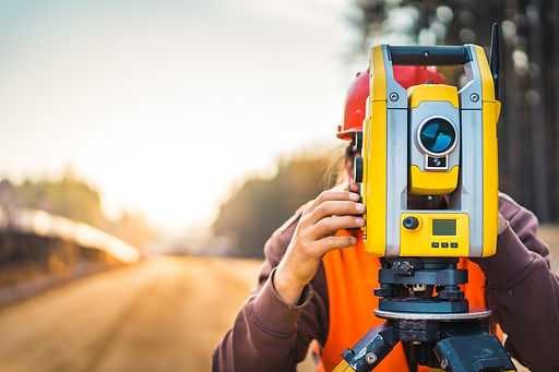 A surveyor conducting a real property report (RPR) in calgary and looking through a tool