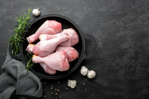 Raw chicken drumsticks, meaty and light pink, neatly arranged for cooking.