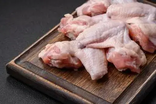 Raw chicken wings, plump and fresh, neatly arranged on a tray