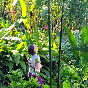 a woman walks in a tropical garden