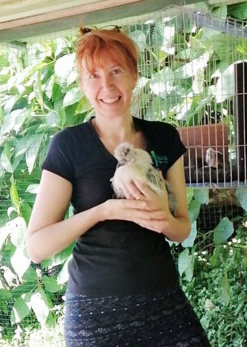 Une femme tient un poulet contre elle