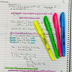 Person taking notes with pen and colorfu