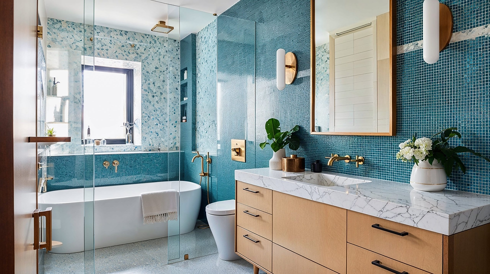 Luxurious bathroom with blue mosaic tiles, marble sink, gold fixtures, and white freestanding bathtub. Bright, serene atmosphere.