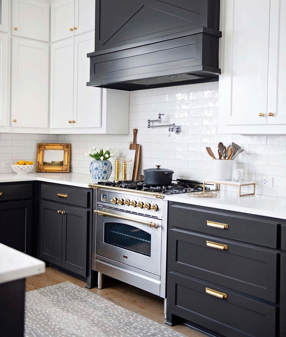 Stylish kitchen featuring black and white cabinets, a modern stove, white backsplash, and decor accents with blue vase and lemons.
