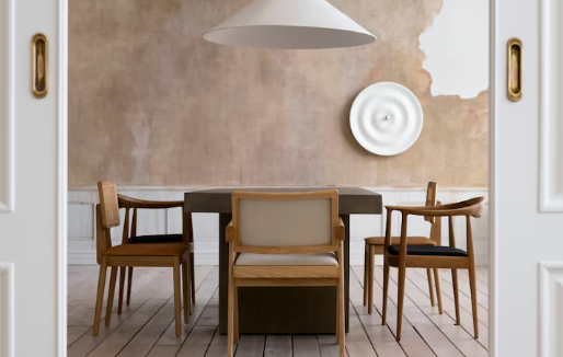 Minimalist dining room with wooden chairs around a rectangular table, pendant lamp above, textured brown wall, and circular wall decor.