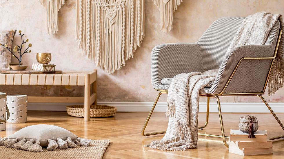Boho Chic Interior Design featuring a cozy armchair with gold accents, a textured throw blanket, a macramé wall hanging, natural wood furniture, and soft neutral decor elements in a stylish living space.