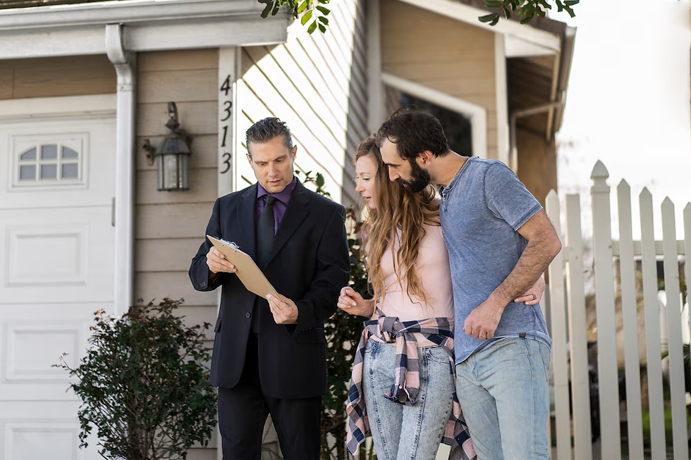 Real estate agent shows paperwork to a couple outside a house with a white fence. The couple looks pleased, and the house number is 4313.