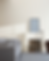 Minimalist room with a white couch beside a fireplace filled with stacked books. A mirror and ceramics sit on the mantel, and soft shadows cast.