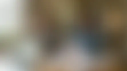 Couple stressed over bills at kitchen table with laptops, documents, and calculator. Sunlight through window, plants, and past due notice visible.