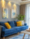 Elegant living room with a blue sofa, yellow pillows, and plant. Blue and yellow botanical art on the wall. Soft lighting and sheer curtains.