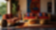 Cozy room with red and orange patterned cushions, abstract wall art, wooden furniture, and a vibrant rug. Sunlit, warm atmosphere.