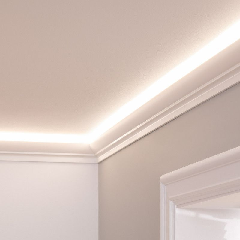 Ceiling corner with soft white LED lighting along the edges. Smooth white molding contrasts against light gray walls, creating a serene ambiance.