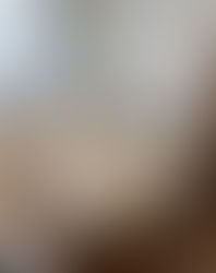 Beige sofa and stone coffee table with books create a cozy, modern living room. Large mirror, parquet floor, and soft light enhance calmness.