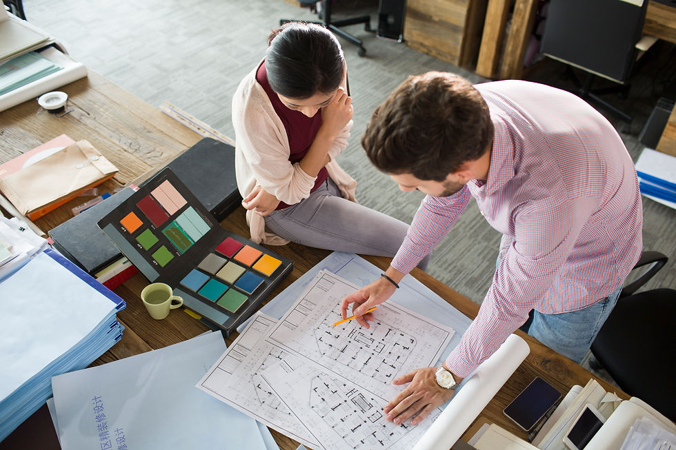 Designers collaborating on a West Plains interior project with floor plans and a color palette.