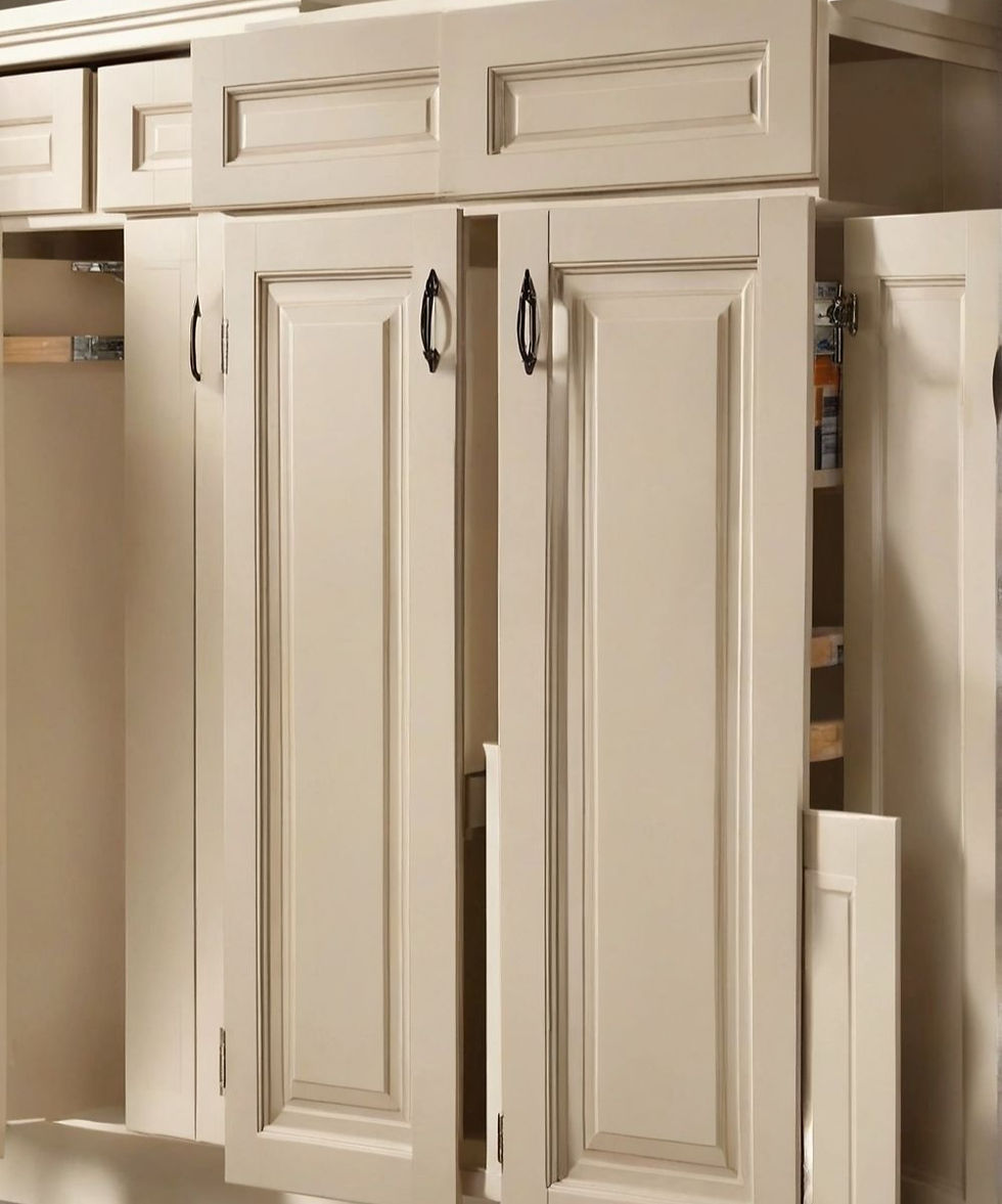 Cream kitchen cabinets with ornate panels, partially open to reveal storage shelves. Black handles, clean and elegant design.