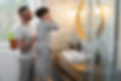 Father and son in gray pajamas, son brushing teeth in a modern bathroom with mirror and plants. Warm lighting, morning routine.