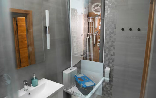Modern bathroom with gray tiles, white sink, and mirror. Visible plumbing behind glass panel; blue backpack on toilet seat. Minimalist design.