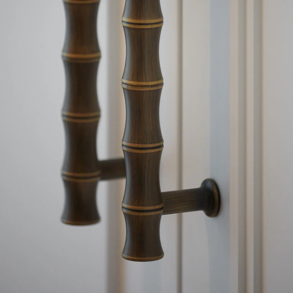 Close-up of two bamboo-style handles on a white cabinet. Dark brown with gold stripes, creating a sleek, natural look.