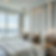 Elegant bedroom with a plush bed, neutral pillows, and hanging lamps. Large window offers a serene lake view, creating a calming ambiance.
