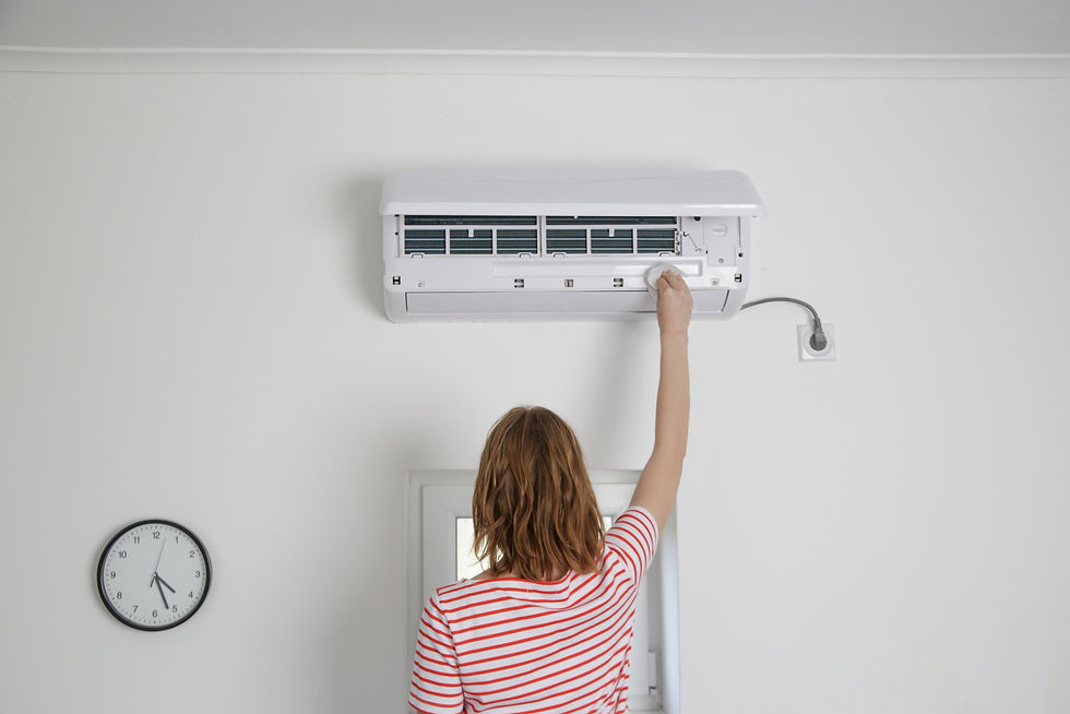 Person adjusts wall-mounted air conditioner in a white room. Red-striped shirt. Clock reads 3:05. Bright, minimalistic setting.