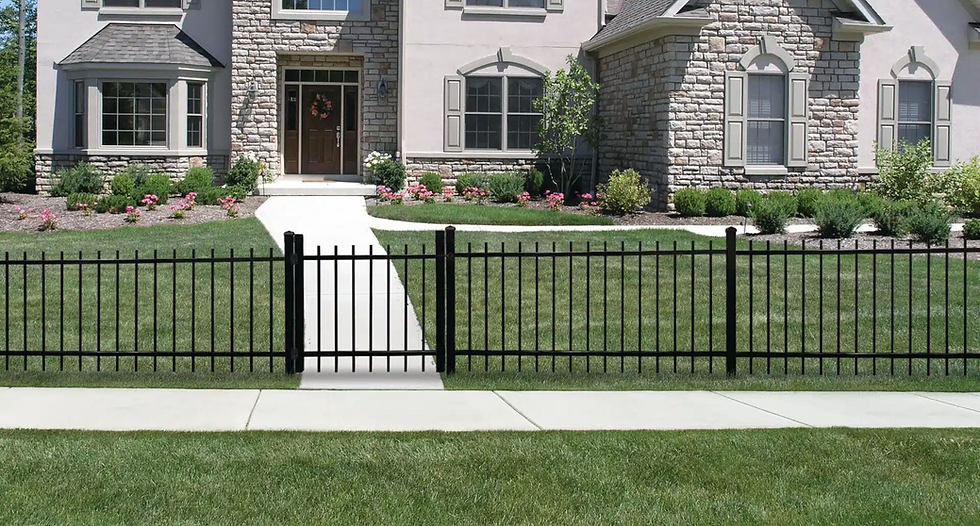 Stone house with arched windows, lush green lawn, and a black metal fence. A path leads to a flower-decorated door, creating a welcoming feel.