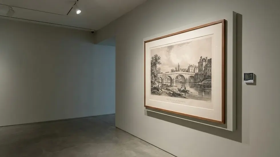 Framed sketch of a bridge in an art gallery, displayed on a neutral wall with overhead lighting. Digital wall display shown nearby.