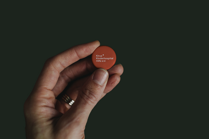 Hand Holding Pin Button Mockup