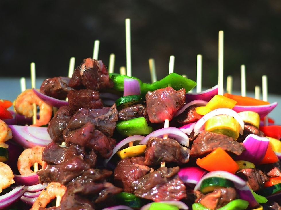 Brochettes de viande, crevettes, poivrons et oignons en gros plan, sur fond sombre, aspect appétissant.