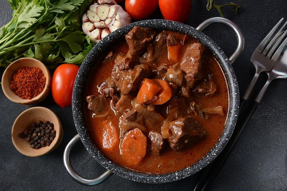Boeuf bourguignon dans une casserole et ses ingrédients autour