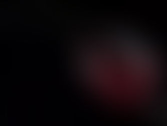 Vin rouge versé dans un verre sur fond noir, avec un mouvement net du liquide.