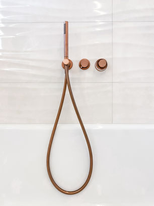 Exklusives Badezimmer mit roségoldenen Armaturen und Design-Waschtisch