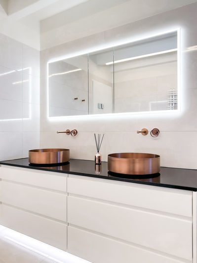 Exklusives Badezimmer mit roségoldenen Armaturen und Design-Waschtisch