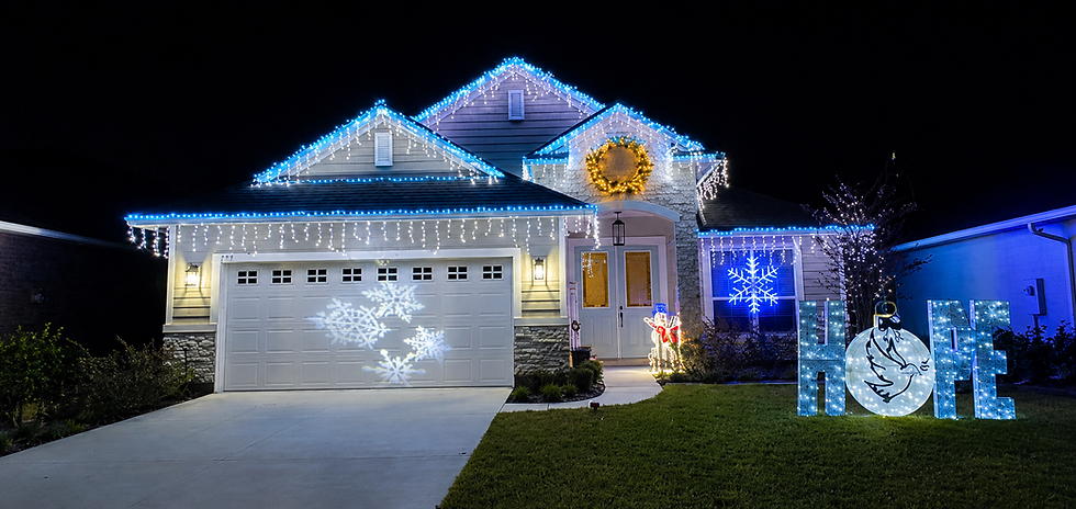 House with blue holiday lighting and HOPE lawn sign