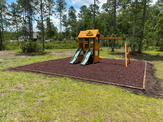 Outdoor furniture assembly of a wooden playset on mulch.