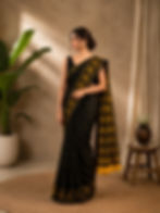Woman in black saree with yellow ethnic motifs