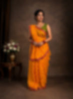 Woman in a yellow Chunari cotton malmal saree with red border