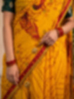 Close-up of a yellow cotton malmal saree with red ethnic motifs